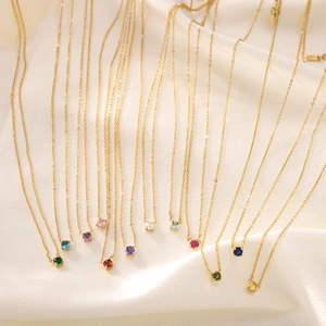 Gros plan de colliers dorés élégants avec des cristaux ronds de multiples couleurs vives