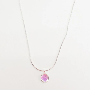 Detailed macro view of an oval pendant necklace with purple opal inlay on a snake chain