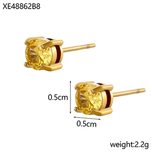 Détail de boucles d'oreilles dorées de 0,5 cm avec zircone jaune et sertissage à quatre griffes