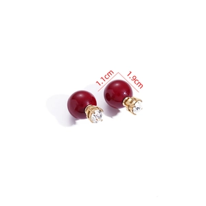 Detail view of double-sided red pearl earrings with gold base and size measurements