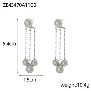 Detailed view of elegant silver tassel earrings with hanging faux pearls on white backdrop