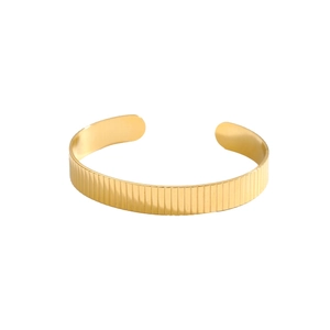 Close-up of golden ribbed texture on an adjustable C-shaped open cuff bracelet