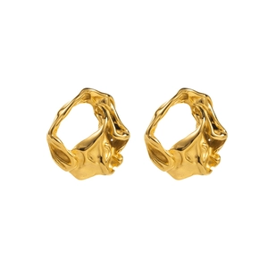 Macro view of gold hammered heart earrings showing molten metal texture and luxury finish