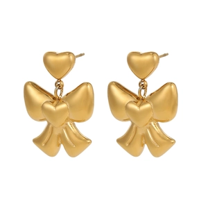 Detailed view of golden bow earrings with heart studs and polished metallic finish