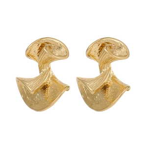 Close-up of golden abstract bow earrings with delicate hammered texture and polished finish