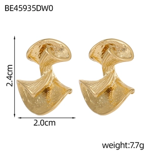 Detail of gold bow pearl earrings with hammered texture and 2.4cm height measurement