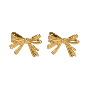 Macro detail of golden bow earrings with elegant ribbon texture and vintage metallic finish