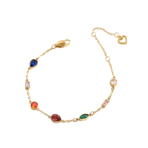 Detail of adjustable gold bracelet with colorful faceted gems and heart pendant