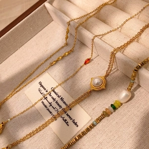 Exquisite gold layered necklaces with red gemstone and a baroque pearl beaded bracelet