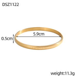 Detail of golden metal bracelet with 5.9cm inner diameter and engraved side text