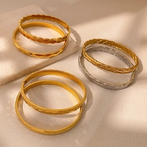 Set di bracciali geometrici con motivi a squame di pesce e nido d'ape in oro e argento