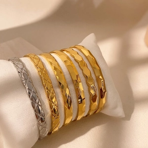 Set di sei bracciali geometrici lucidi con motivi a scaglie e martellati su morbido cuscino