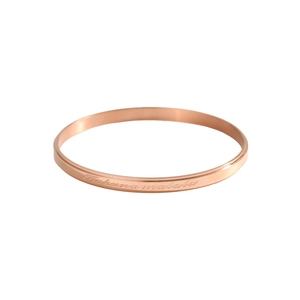 Close-up of rose gold bangle with Hakuna Matata engraving and polished finish
