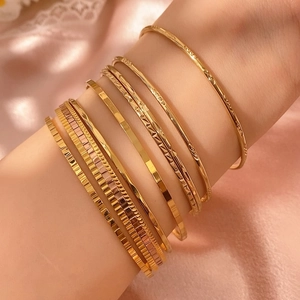 Set di bracciali dorati minimalisti con texture geometriche e finitura liscia da donna
