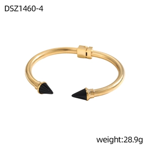 Dettaglio del bracciale dorato aperto con punte nere, peso 28,9g e design punk