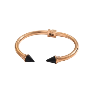 Dettaglio del bracciale rigido oro rosa con punte nere e chiusura a cerniera quadrata