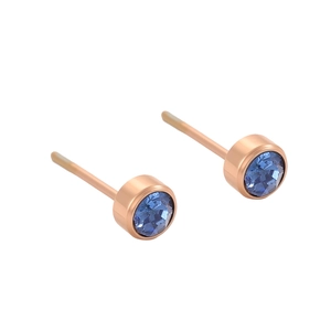 Détail de boucles d'oreilles or rose avec cristal bleu rond serti clos