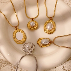 Parure de colliers vintage français avec pendentifs ovales et perles sur assiette