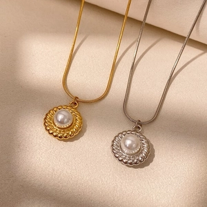 Détail de colliers vintage dorés et argentés avec pendentifs perles et chaînes serpent