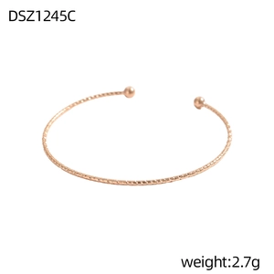 Detail eines roségoldenen Kugelarmreifs mit feinen horizontalen Gravuren auf dem Band