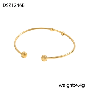 Detailansicht eines goldenen Kugelarmreifens mit mattem Finish und offenem Design