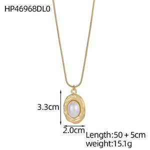 Détail du collier vintage doré avec pendentif ovale irrégulier et perle centrale