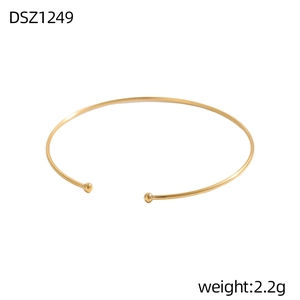 Detailansicht eines verstellbaren goldenen Armreifs mit polierten Kugeln und Minimal-Design