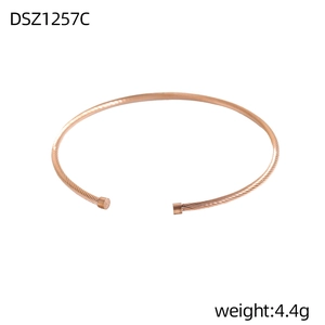 Detailansicht eines roségoldenen verdrehten Armreifs mit zylindrischen Endkappen