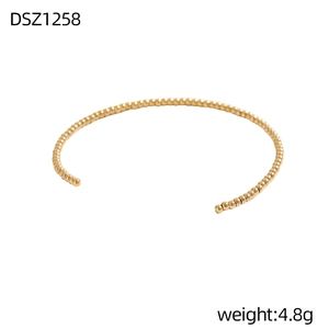 Detailansicht eines minimalistischen goldenen Perlenarmreifs mit hochglanzpoliertem Finish