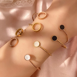 Detail von eleganten C-förmigen Armbändern mit Muschel- und Achat-Einsätzen am Handgelenk