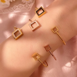 Detailsicht luxuriöser geometrischer Goldarmreifen mit Emaille-Inlay auf Seidenstoff