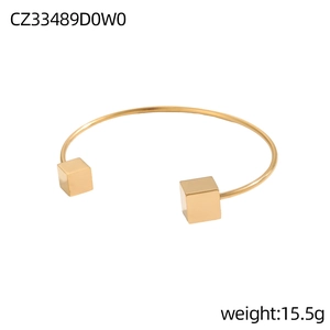 Bracciale rigido aperto in oro minimalista con terminali a cubo geometrici, peso 15,5g su bianco