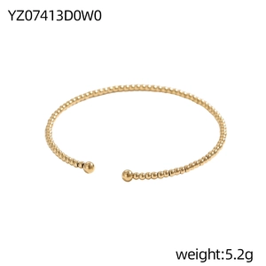 Makroaufnahme des minimalistischen goldenen Perlenarmreifs mit polierter Oberfläche
