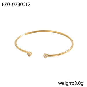 Detail eines vergoldeten C-Manschettenarmbands mit Herzenden und funkelnden Zirkonen