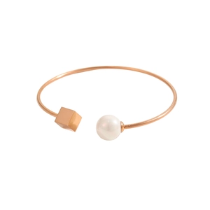 Dettaglio del bracciale rigido oro rosa con perla e cubo geometrico lucido