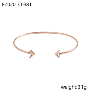 Detail eines roségoldenen C-Armreifs mit weiß emaillierten V-Enden im schicken Design