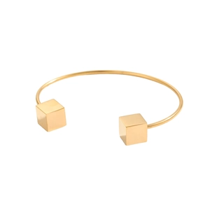 Dettaglio del bracciale rigido dorato regolabile con accenti di cubi minimalisti solidi