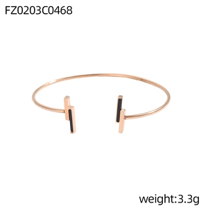 Detailansicht des roségoldenen C-Armreifs mit schwarzen geometrischen Elementen