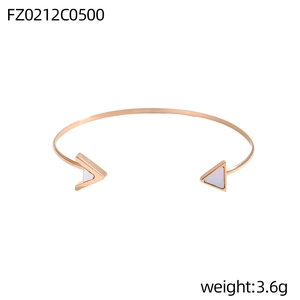 Detail eines roségoldenen C-förmigen Armreifs mit weißen Perlmutt-Dreieckseinlagen