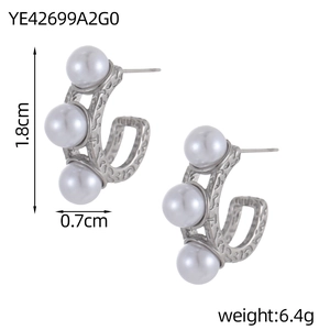 Close-up of C-shaped silver earrings with vintage texture and vertical pearl inlay
