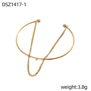 Dettaglio del bracciale dorato a doppio anello con catena a sfere e stile minimalista