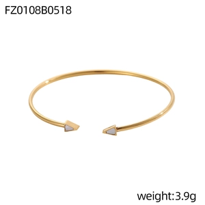 Dettaglio del bracciale rigido dorato da 3,9g con punte a triangolo e intarsi bianchi