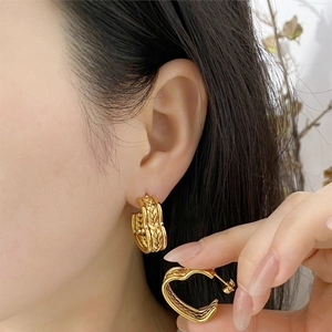 Close-up of golden vintage wheat-weave textured C-shaped hoop earrings for women