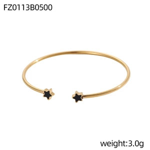 Dettaglio del bracciale rigido dorato con stelle nere e peso di 3,0 g dallo stile moderno