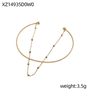 Dettaglio del bracciale dorato a doppio strato con anello diamantato e catenina