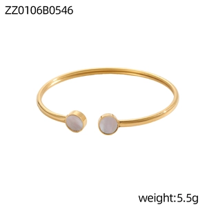 Dettaglio del bracciale rigido dorato con intarsi in conchiglia bianca e design a stella