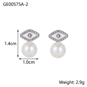 Detalle de pendientes de ojo de plata con esmalte blanco y una perla colgante