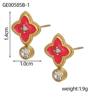 Detalle de pendientes de trébol rojo con bordes de cuentas doradas y circonitas