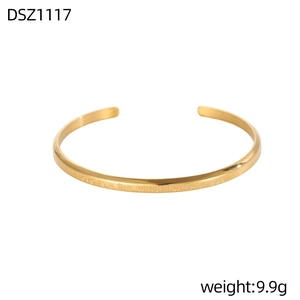 Detalle de brazalete dorado ondulado con grabado de Love is a fire which burns unseen