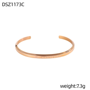 Detalle macro de la pulsera plisada de oro rosa con logotipo grabado y textura geométrica